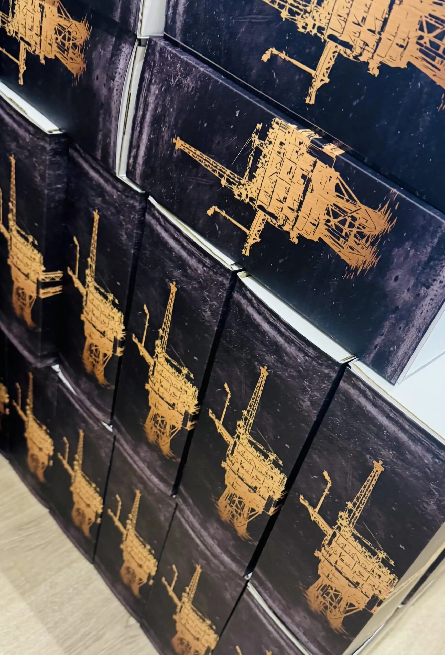 Apache gift boxes printed with gold oil rig artwork, stacked ready for delivery