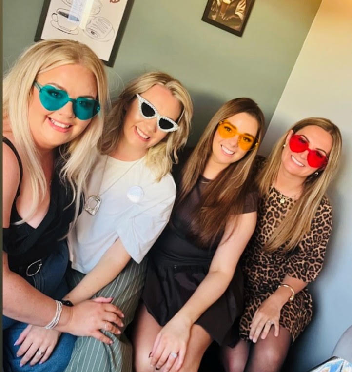 Four friends in novelty sunglasses at the taproom
