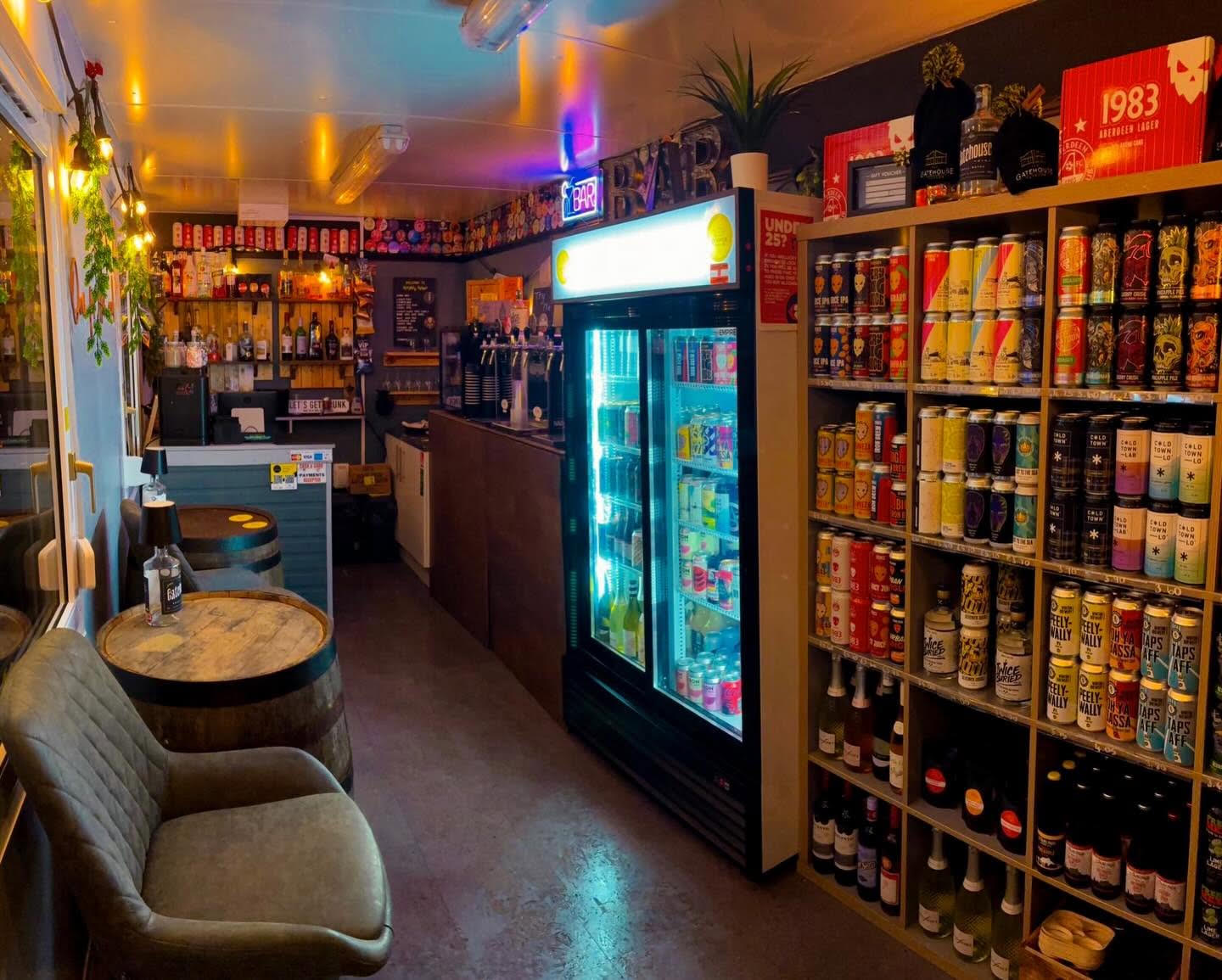 The bottle shop, with a fridge of cans and shelves of bottles behind the bar stools